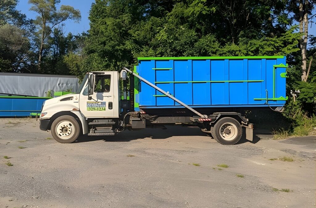 A blue Simplified Dumpster container set beside a Grand Ledge, MI property, offering easy access for renovation debris and clutter removal.